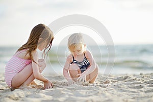 Two little sisters having fun on a beach