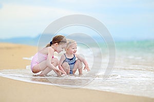 Two little sisters having fun on a beach