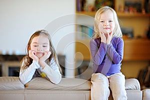 Two little sisters having fun at home