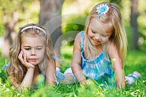 Two little sisters having fun in summer park