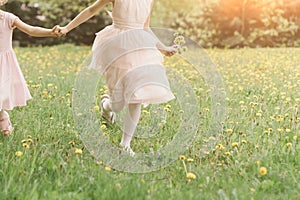 two little sisters running across the lawn on a spring day. feet