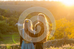 Two little sisters at sunset in the fall in nature.