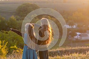 Two little sisters at sunset in the fall in nature.