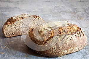 Two loafs or miche of French sourdough, called as well as Pain de campagne, on display on a wooden table.