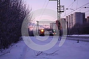 Two locomotives are parallel course. Freight and passenger train moving to Moscow. Russia. Early morning