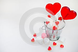 Two Lollipops heart shaped in Small bucket with sweets on white