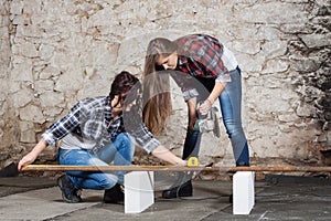 Two long-haired young woman with an angle grinder