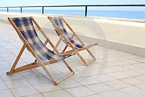Two longes on veranda on sea