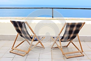 Two longes on veranda on sea