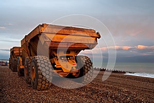 Two lorries on a pebble beach