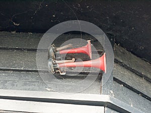 Two loud red horns on a black shed background at dock