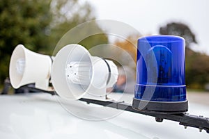 Two loudspeaker and blue lights on top of police car