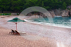 Two lounge chairs with sun umbrella on beach. Perfect vacation concept. Coastal landscape. Relaxing