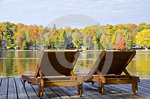 Two Loungers on a Boardwalk by a Lake in the Fall