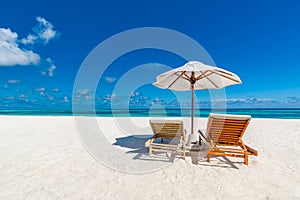 Two loungers on white sand in Maldives. Tropical beach landscape for honeymoon or vacation background