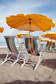 Two lounges and yellow umbrella on the beach