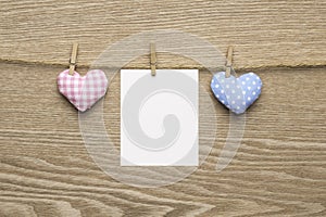 Two love hearts with blank instant photos over wooden background