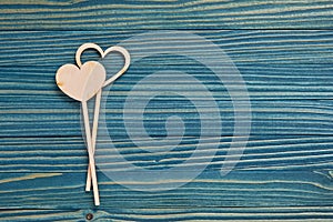 Two love hearts on a blue wooden background