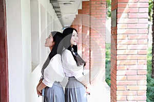 Two lovely Asian Chinese pretty girls wear student suit in school best friends smile laugh