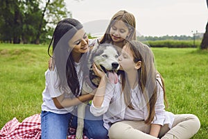 Two lovely sisters with their mother and Husky dog at park. Happy family with their pet in countryside