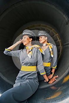 Two lovely stewardesses sitting inside the aeroengine