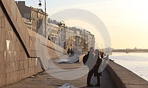 Two lovers kissing at sunset on river shore.