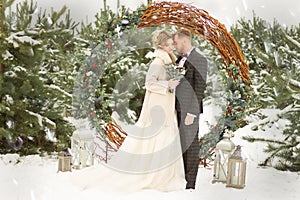 Two lovers, a man and a woman, a wedding in winter. bride and groom love. against the backdrop of decor and trees, snow. holding a