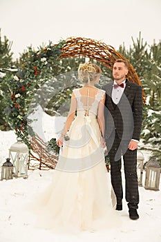 Two lovers, a man and a woman, a wedding in winter. bride and groom love. against the backdrop of decor and trees, snow. holding a