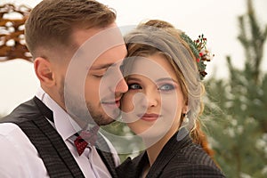 Two lovers, a man and a woman, a wedding in winter. bride and groom love. against the backdrop of decor and trees, snow. holding a