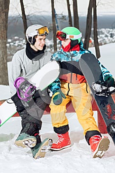 Two loving amorous snowboarders resting on the top of the ski slope