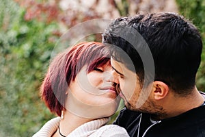 Two loving people 20-29 years old, kissing outdoors on Valentine`s Day