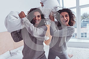 Two loving sisters wearing grey knitted sweaters