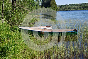 Two low boats standing on the shore of a beautiful forest lake