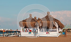 Two luxurious romantic gazebo with palm leaf roof for relaxing on a tropical sandy beach