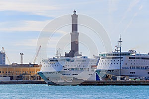 Two luxury Cruise Ships in front of the lighthouse in Genoa, Italy