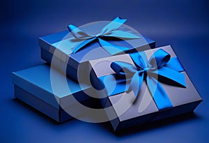 Two Luxury gift boxes with a blue bow on dark blue. Side view monochrome