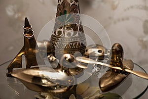 Two luxury golden engraved wedding rings on bronze boat statuette near gold duck figurine closeup