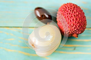 Two lychee fruits and seed wooden background
