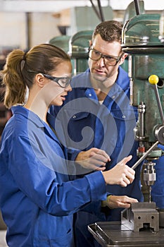 Two machinists working on machine