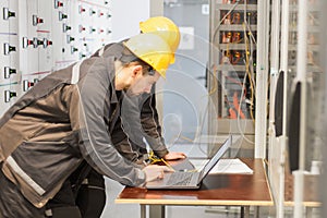 Two maintenance engineers inspect relay protection system with l