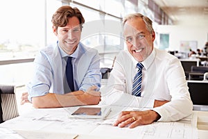Two male architects working together, looking to camera