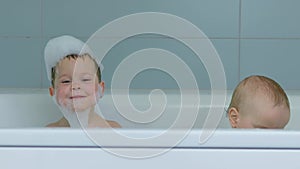 two male baby brothers take bath soap foam playing together put foam on head