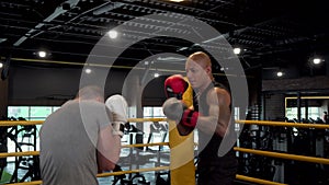 Two male boxers sparring in boxing ring at the gym