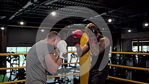Two male boxers sparring in boxing ring at the gym