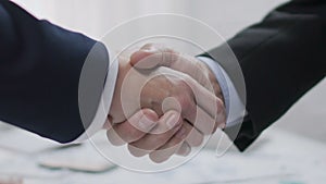 Two male business partners shaking hands, profitable agreement, co-operation