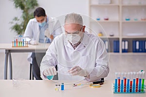 Two male chemists working at the lab during pandemic