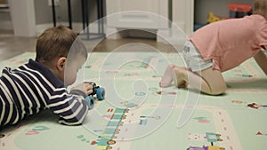 two male children playing toy cars on floor living-room indoors little boys