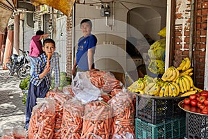 Two male children work in a vegetable shop, Kashan, Iran.