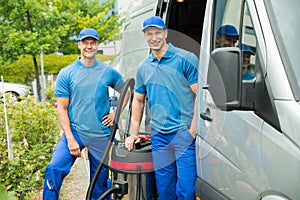 Two Male Cleaners With Vacuum Cleaner