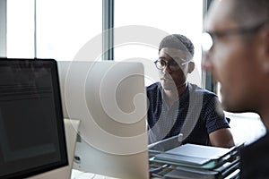 Two male colleagues  working in a creative office, close up, selective focus